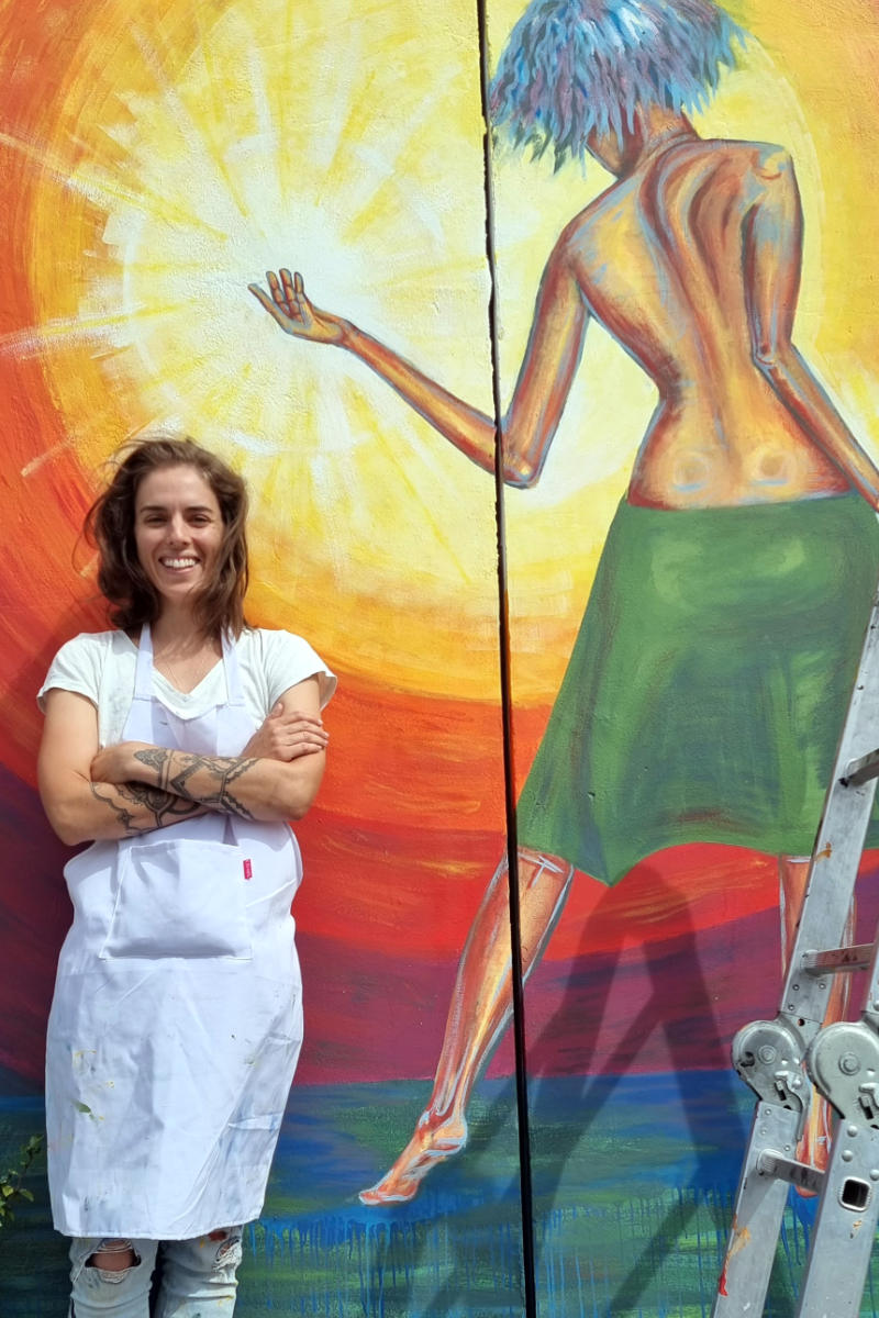 Melany Jane painting a mural in Manenberg, South Africa